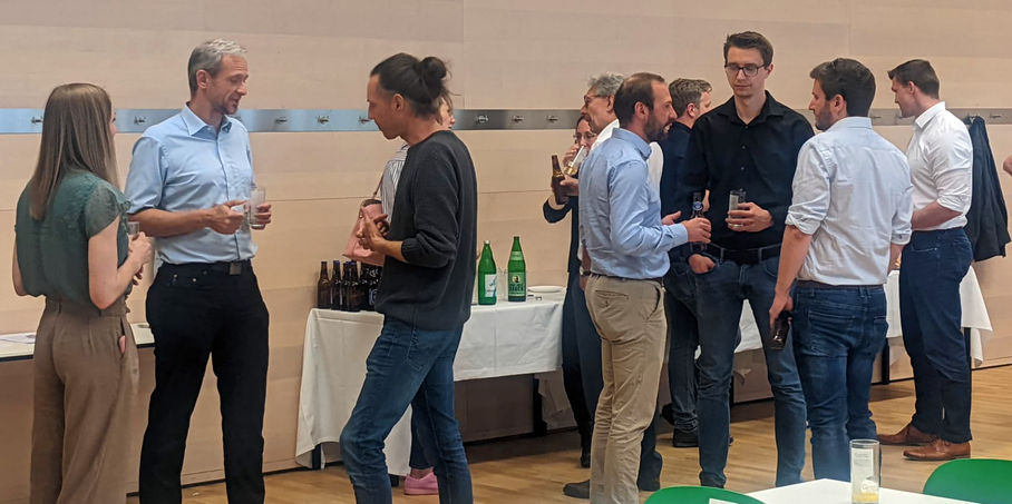 A group of people stand together with drinks.