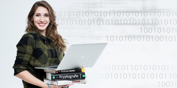 Young woman holds a stack of books with an open laptop on top.