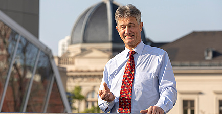 Mann mit Hemd und Krawatte vor einem Kuppeldach