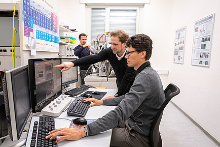 Two researchers in front of a desk working with computers