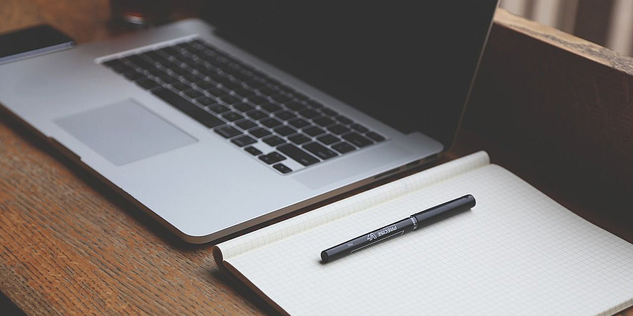 Laptop, notebook, and pen on a desk