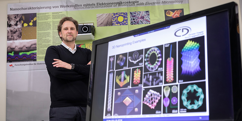 TU Graz researcher stands behind computer screen