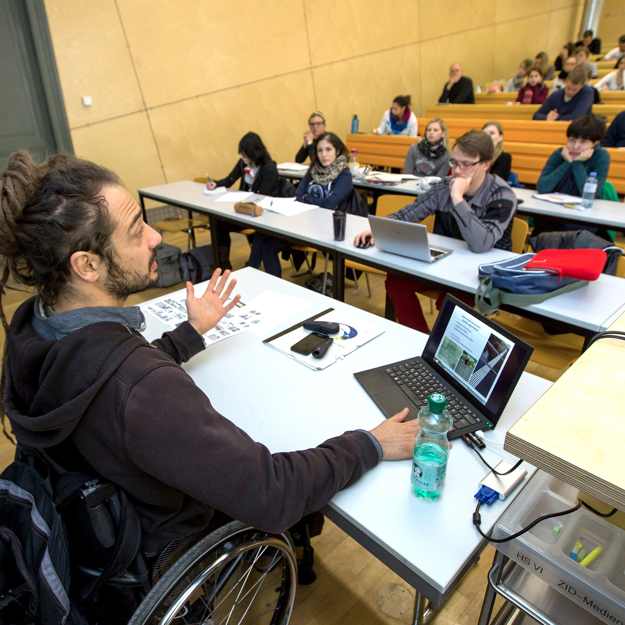 Man in a wheelchair in a lecture hall