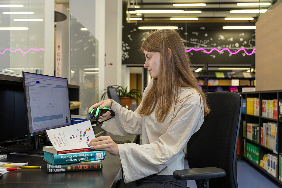 Bildquelle: Frankl – TU Graz Eine Frau hält einen Barcode-Scanner in der Hand, mit dem sie ein Buch einscannt.