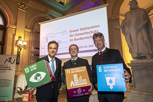 Three men with cardboard cubes in their hands 