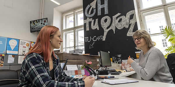 Zwei Frauen sitzen gegenüber an einem Tisch
