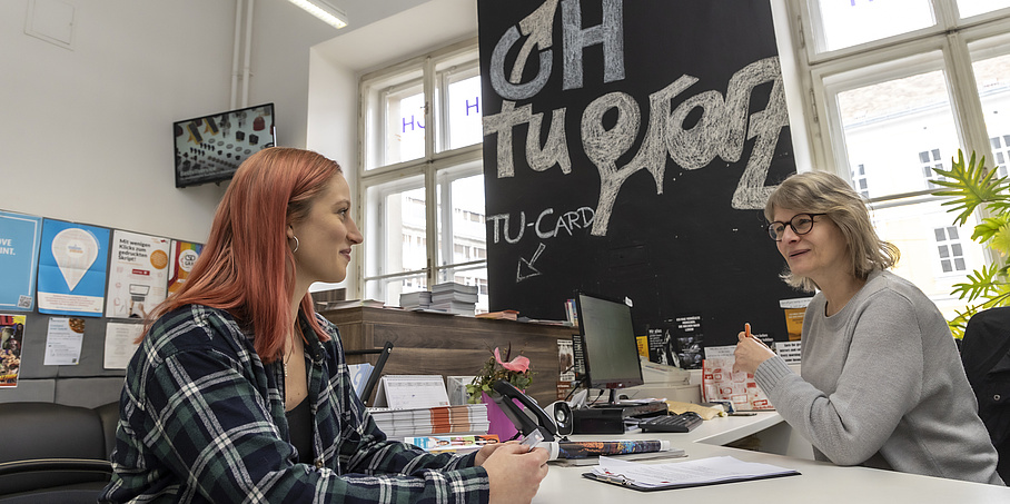 Zwei Frauen sitzen gegenüber an einem Tisch