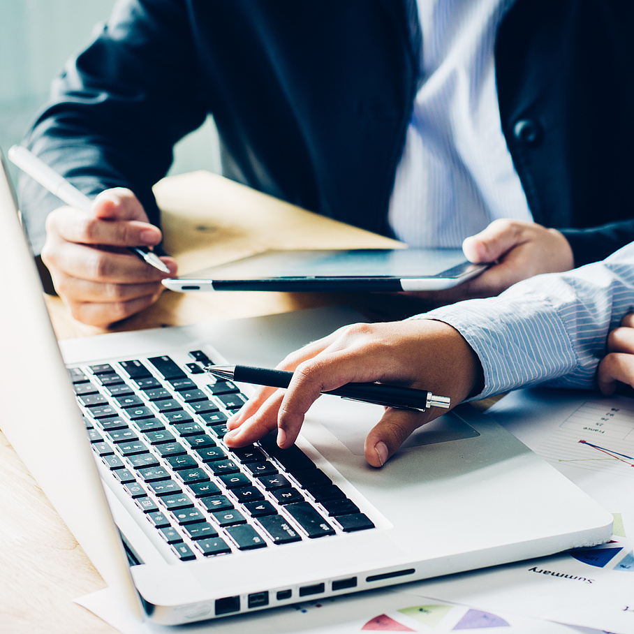 Laptop and tablet are operated by two people.