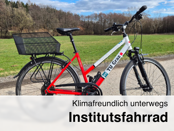 Red and white TU Graz institute bicycle with a large metal rear basket on a country path in front of green meadows and bare trees, text: “Eco-friendly on the road – Institute Bicycle.”