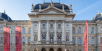 Historisches Gebäude, davor Fahnen mit TU Graz-Logo