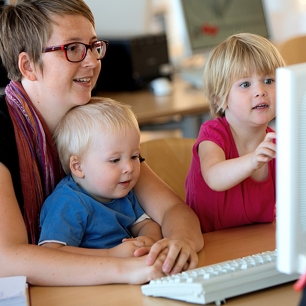 Eine Mutter mit ihren beiden kleinen Kindern vor einem PC. Bildquelle: Lunghammer – TU Graz