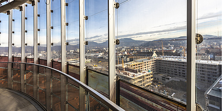 Glasfront mit Blick auf Stadtgebiet und Baustellen