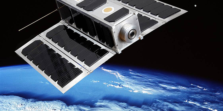 Photomontage of the nanosatellite OPS-SAT in space near the blue planet earth.