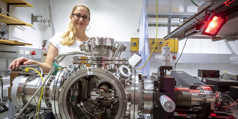 Eien Frau steht in einem Laserlabor.