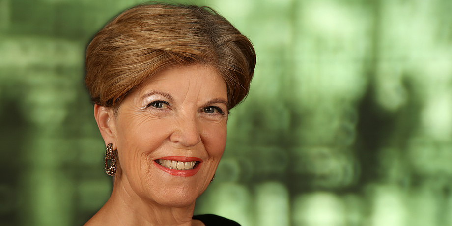 A portrait photo of Karin Schaupp in front of green background.