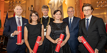 Two women and four men in festive atmosphere