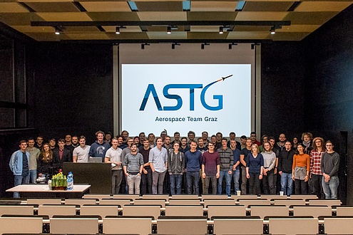 Gruppe Studierender vor einer Videowall im Hörsaal