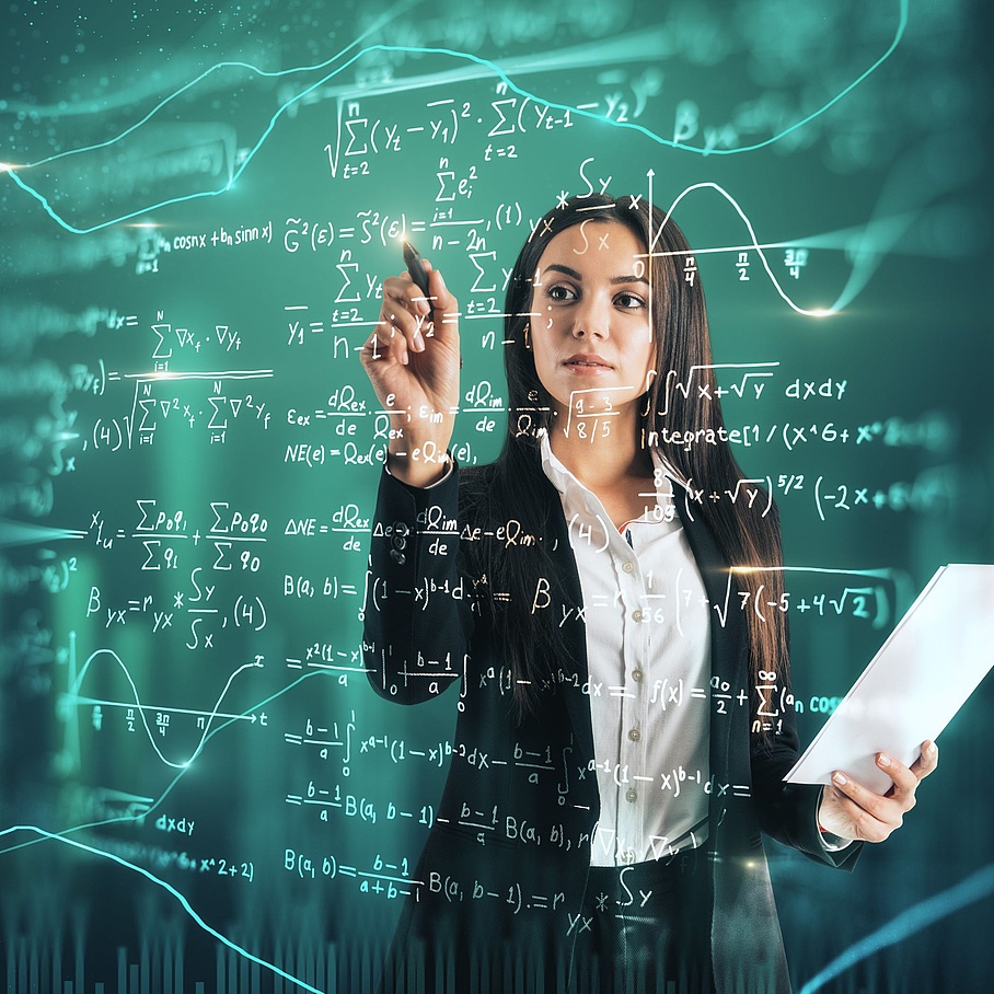 Junge Frau schreibt mathematische Gleichungen auf eine Glastafel. 