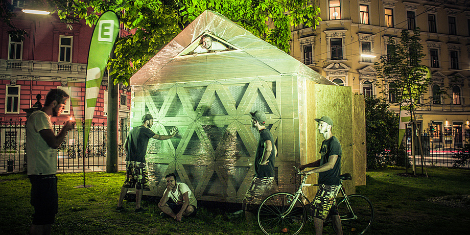 Photomontage with Patrick Ernst and Robert Sterzing at the arcCard shelter2.0, an emergency shelter made of corrugated cardboard, already setup at the Alte Technik Campus.