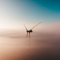 Wind turbine covered by clouds.