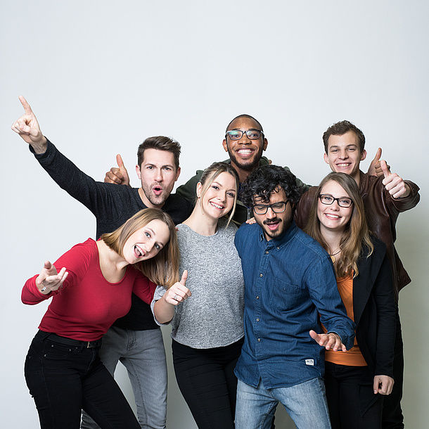 Ein Gruppe Studierender posiert lachend vor der Kamera.