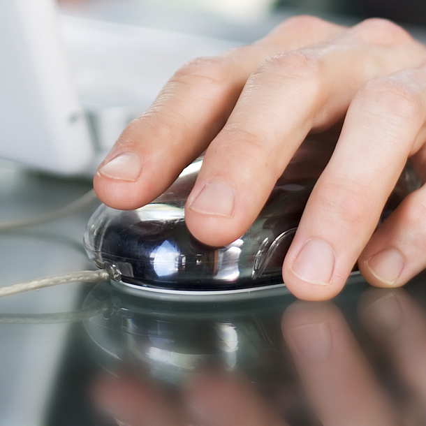 Hand steering a computer mouse, next to it a laptop computer. Photo source: photo-dave - fotolia.com