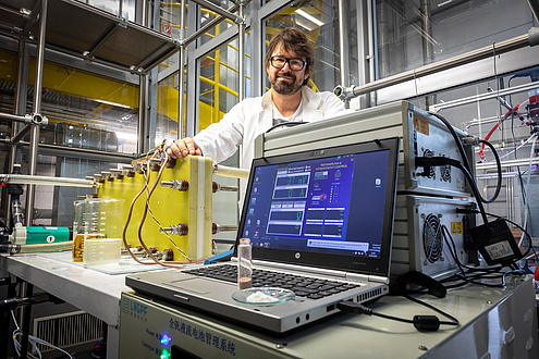 Mann mit Brille vor Bildschirm und Apparatur