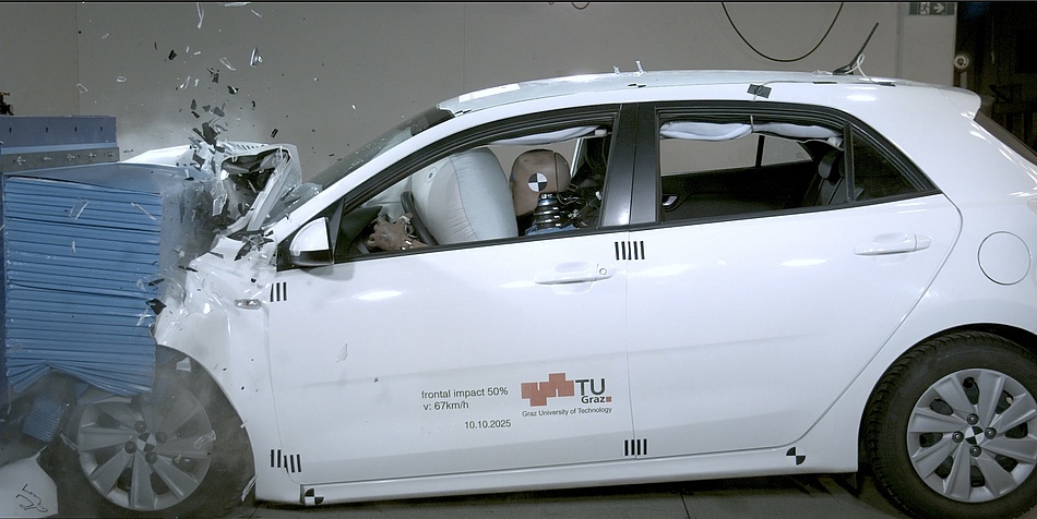 Seitenansicht eines verunfallten Autos mit Crashtestdummys und aufgeblähten Airbags im Inneren