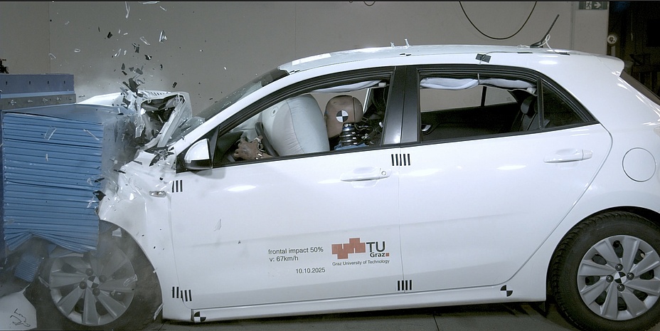 Seitenansicht eines verunfallten Autos mit Crashtestdummys und aufgeblähten Airbags im Inneren