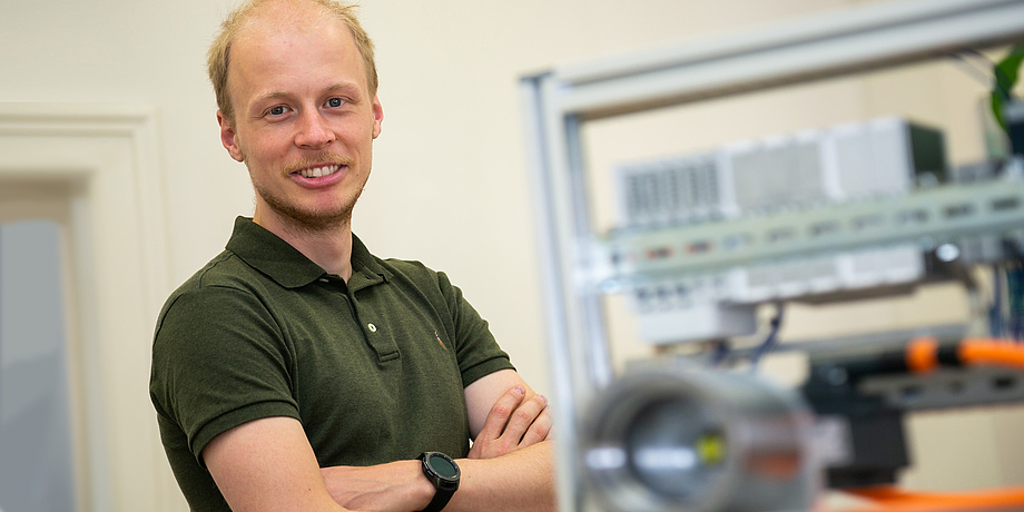 TU Graz researcher with small test bench and gearbox