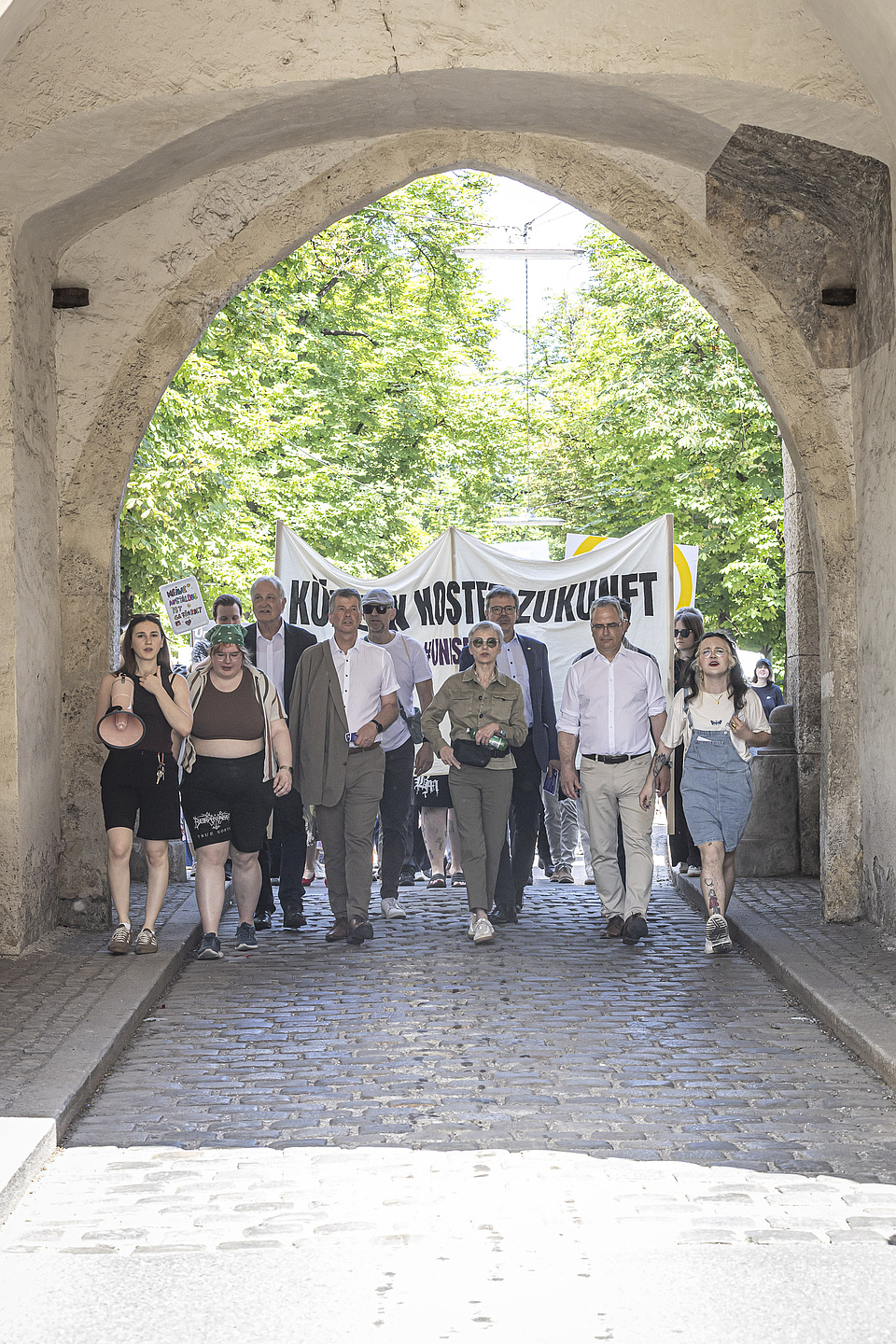 A group of people are walking through a large gateway.