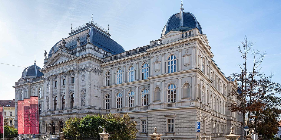 A large old building with several storeys with domes and statues can be seen in the picture.