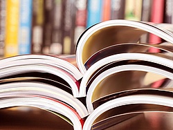 Opened journals in front of a shelf