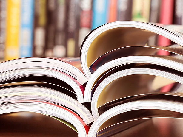 Opened journals in front of a shelf