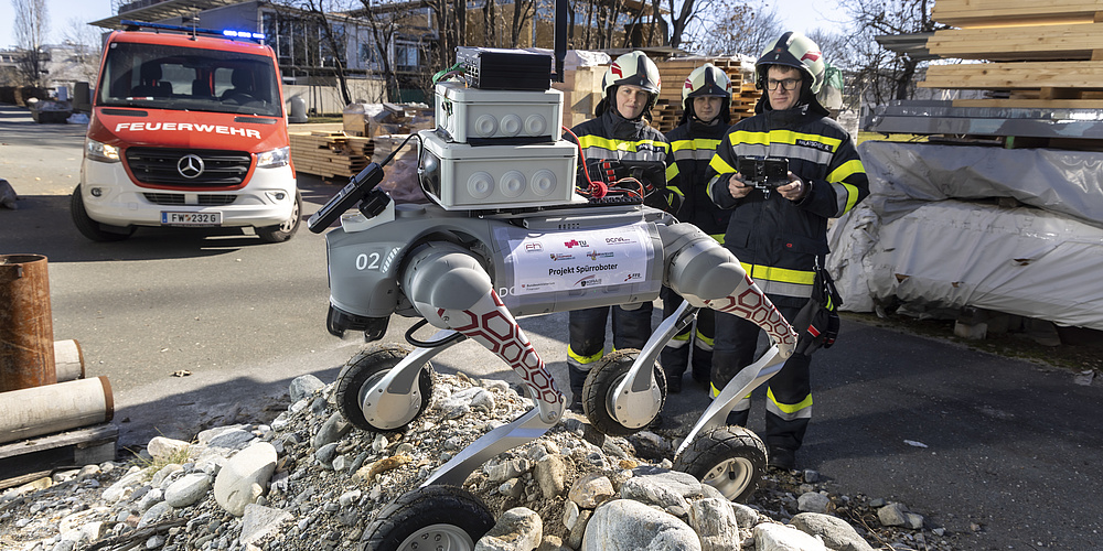 Spürroboter mit vier großen Rädern, Sensoren und Kameras auf einem Geröllhügel bei einer Feuerwehrübung.