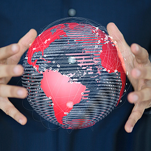 Two hands holding the globe on which two points are marked and connected by lines. Photo source: vege - Fotolia.com