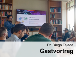 Diego Tejada steht vor einem Bildschirm und hält einen Vortrag vor einer Gruppe von Zuhörern. Der Bildschirm zeigt eine Präsentation mit dem Titel "Mixed Levels of Detail" und "Fully Flexible Temporal Resolution".