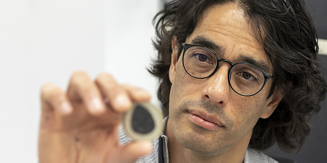 A man holding a material sample.