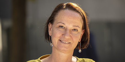 A woman smiles into the camera.