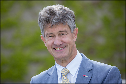 Rector Harald Kainz in blue suit with yellow tie