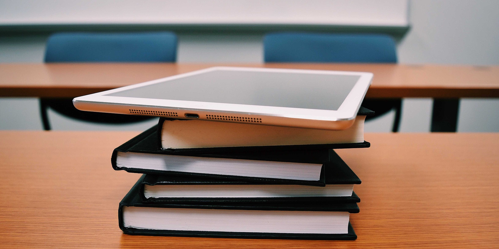 Bücherstapel und Tablet in einem Klassenzimmer