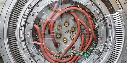 Ein Turbine Center Frame von innen. Zu sehen ist ein Kreis aus Metall mit einigen Löchern und orangen Kabeln.