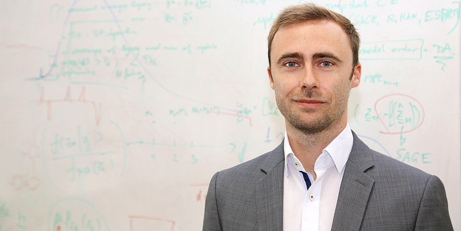 A man in front of a whiteboard.