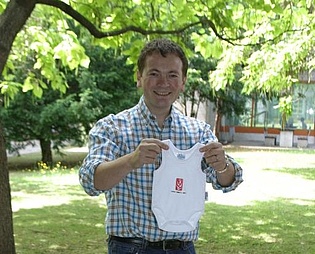 Dr. Fabrice Giuliani posing with a present from his colleagues after his wife gave birth to their first child.