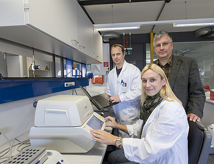 Two men and a woman with laboratory equipment