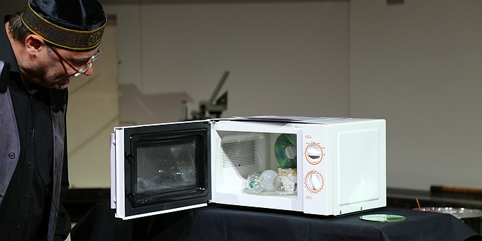 A white microwave mashine filled with light bulbs