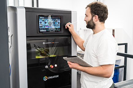 Man in front of 3D printer