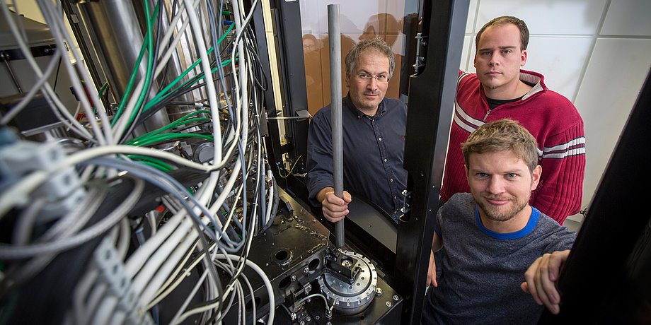 Three researchers with a microscope.