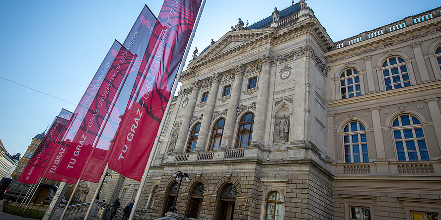 The Alte Technik at Rechbauerstrasse 12, flying five red TU Graz flags.