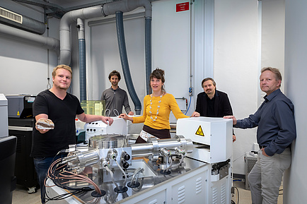 Group of Tu Graz researchers in front of a mass spectrometer